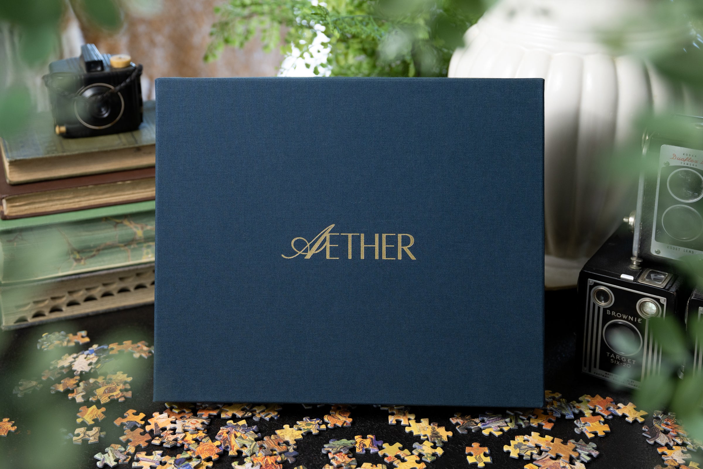 Aether puzzle's blue linen box with gold foil stamped logo- sustainably made in the USA