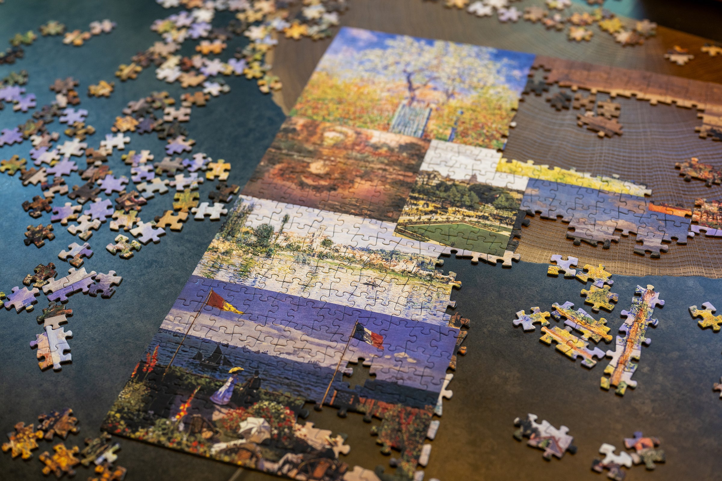 Aether's Claude Monet jigsaw puzzle with a partially completed landscape scene on a wooden surface.